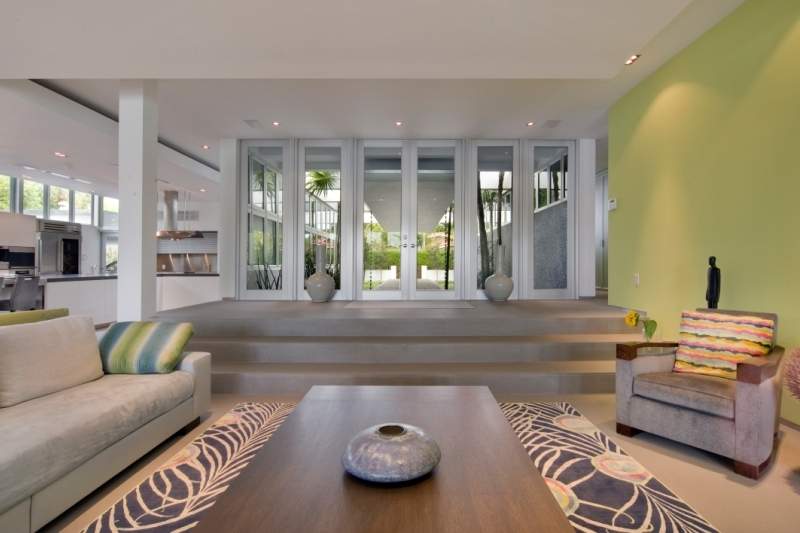 Another view of the living area, colorful accent pillow, dark coffee table with gray and white patterned rug