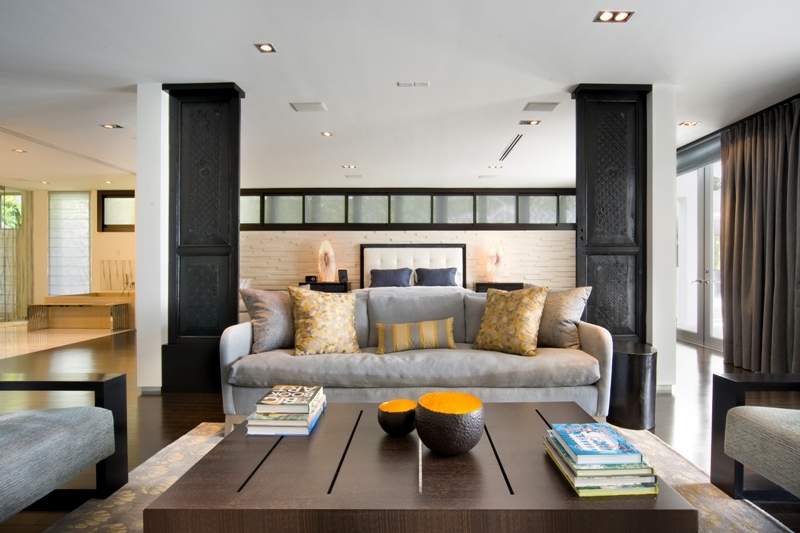 Indoor living area with light gray couches, yellow accent pillow square dark wood coffee table