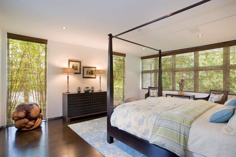 Bedroom with four poster bed, shades of white, light blue and green, accents of brown